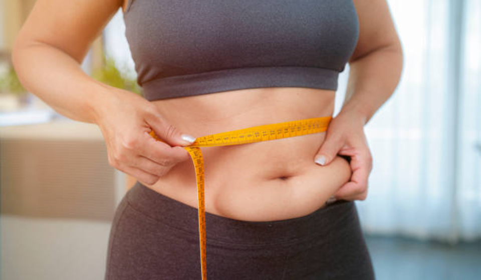 Plus size woman squeezing and measuring her waist